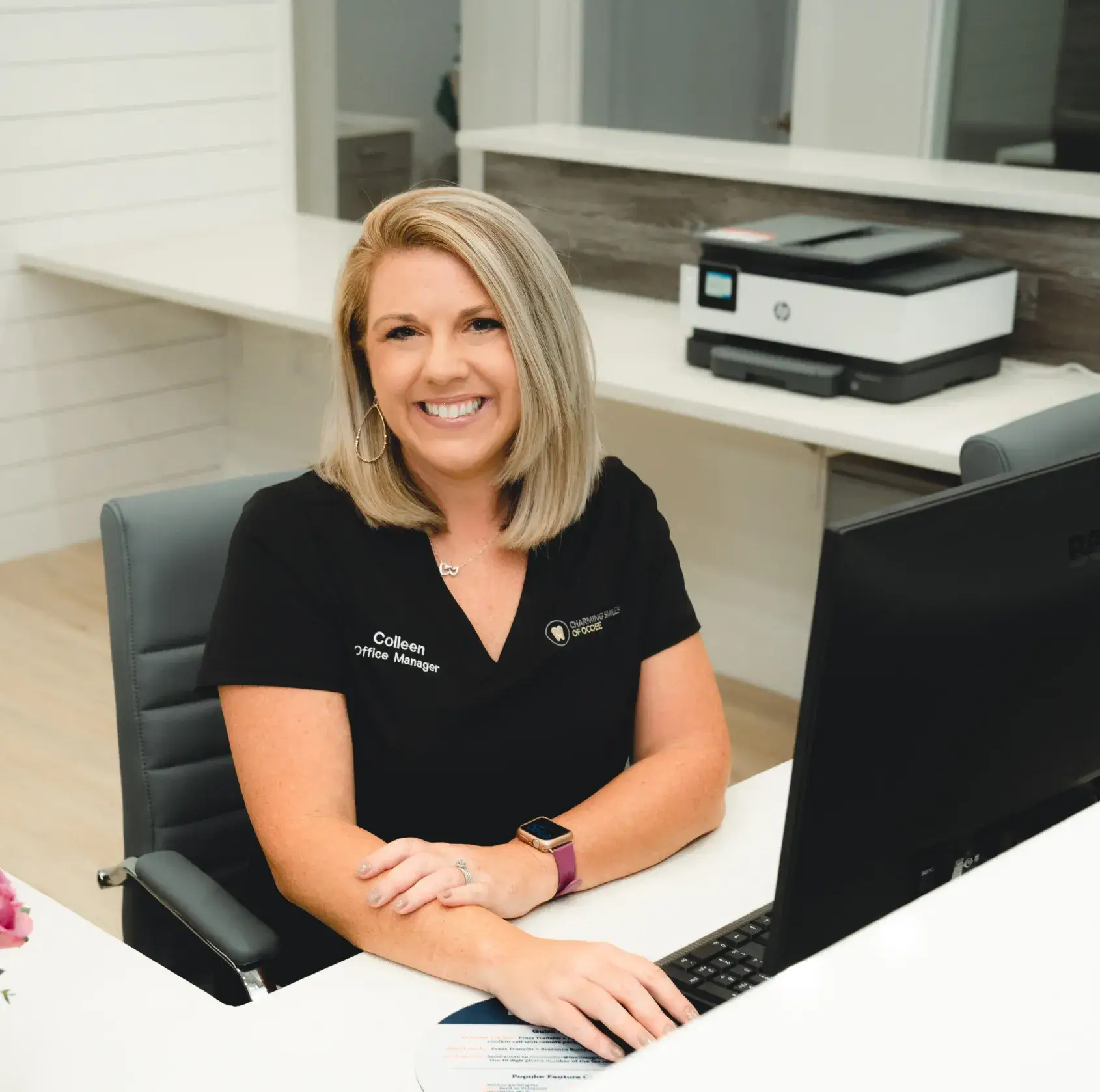 Charming Smiles of Ocoee team member smiling while assisting a patient with savings plan paperwork